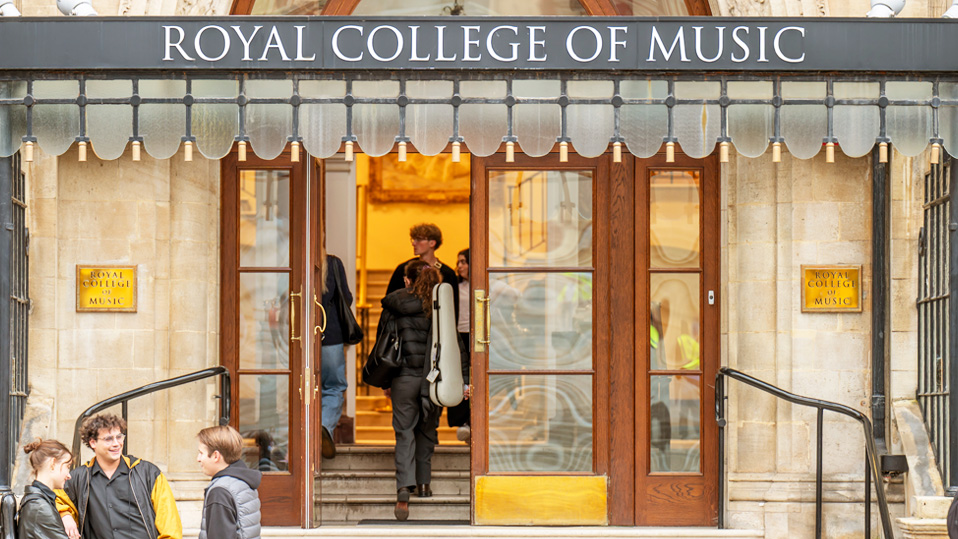 A building entrance with students chatting near the entrance, with the entrance stating "Royal College of Music"